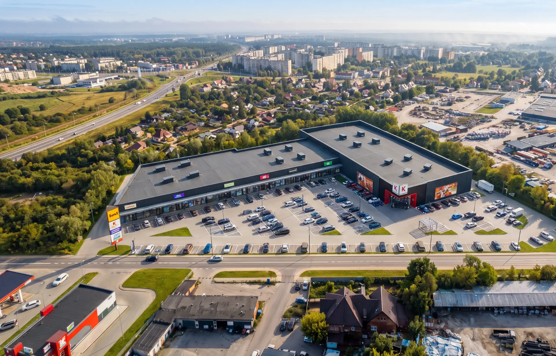 Nowoczesny park handlowy SHOPLAND Starogard Gdański z drewnianą elewacją o zmierzchu